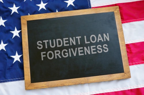 Student loan forgiveness concept. USA flag and blackboard on it.