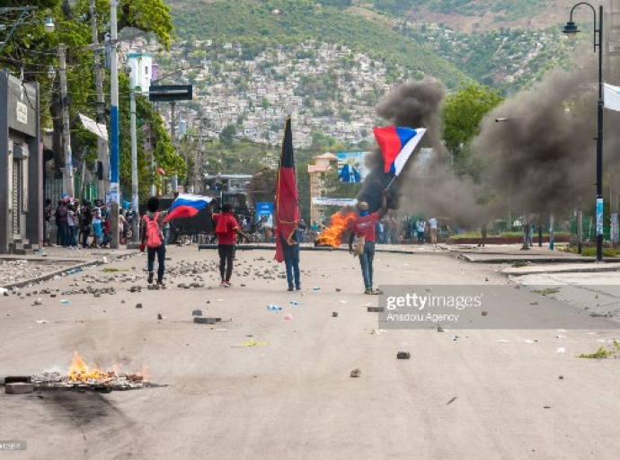 PORT-AU-PRINCE, HAITI - MARCH 28: Protesters carry Russian flags within clashes with police during a protest to denounce the draft constitutional referendum carried by the President Jovenel Moise on March 28, 2021 in Port-au-Prince, Haiti. (Photo by Sabin Johnson/Anadolu Agency via Getty Images)