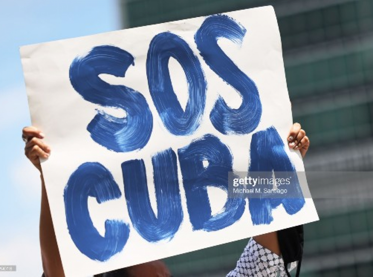 NEW YORK, NEW YORK - JULY 14: A person holds up a protest sign as people gather calling for help for Cuban protestors on the island in front of the United Nations on July 14, 2021in New York City. A small group of people gathered in front of the United Nations in support of the people of Cuba who have been protesting against the communist regime due to food shortage and worsening economic crisis that has been exasperated by the coronavirus (COVID-19) pandemic. The protest on the island has been the largest anti-government protest in decades. (Photo by Michael M. Santiago/Getty Images)