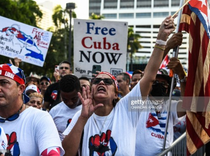 A protestor shouts slogans as people hold "Free Cuba" signs during a rally in calling for Freedom in Cuba, Venezuela and Nicaragua, in Miami, on July 31, 2021. - Human rights groups accuse Cuba's rulers of using censorship and fear tactics to repress historic anti-government demonstrations -- the biggest protests since the revolution that brought Fidel Castro to power in 1959. (Photo by CHANDAN KHANNA / AFP) (Photo by CHANDAN KHANNA/AFP via Getty Images)