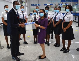 Cheddi Jagan International Airport workers pose for a demonstration of COVID protocols. (Image from the Cheddi Jagan International Airport website)