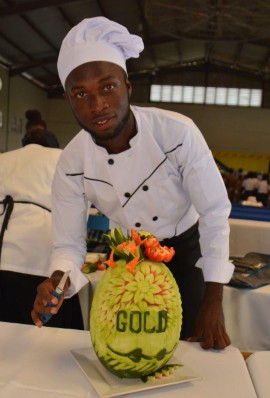 Chef Kimarley Russell poses with his gold-medal winning “Fruit and Vegetable Carving” entry at a previously held Regional Culinary Arts Finals.