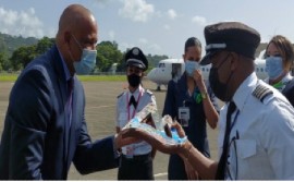Tourism Minister Dr. Ernest Hilaire presenting a gift to CAL’s Captain Dale Harrison