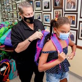 Chairman Jose “Pepe” Diaz helps students during his annual book bag event. (Photo by Ryan Holloway, Miami-Dade County)