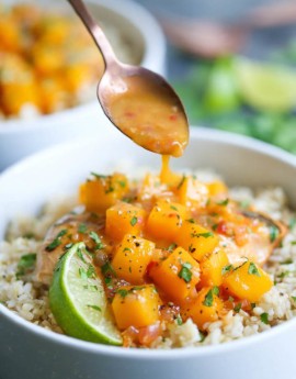 Chicken with mango chunks over a bed of rice.