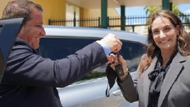 The 2021 Principal of the Year Rachel B. Autler, right, receives the keys to her new Toyota Highlander Hybrid from Anthony Damato from Toyota of North Miami.