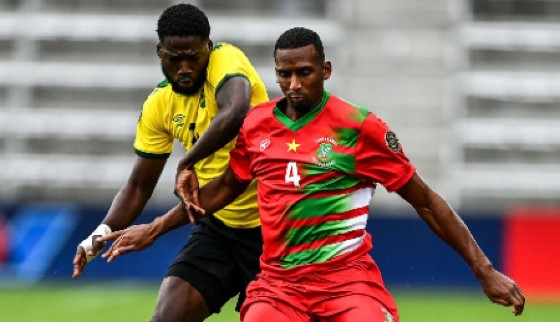 Goal-scorer Shamar Nicholson challenges Suriname’s Dion Malone during Monday’s contest.