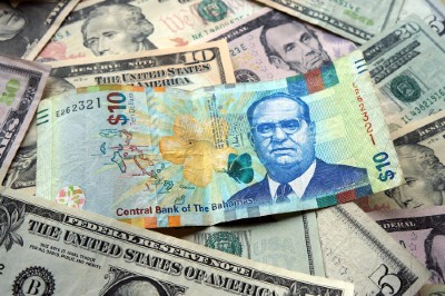 10 Bahamian dollar (BSD) bill surrounded by US dollar bank notes