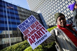 A woman in New York City holds a placard in support of Temporary Protected Status for Haitians in this 2017 file photo. On May 22, 2021, the Biden administration granted eligible Haitian nationals living in the United States the chance to apply for a new 18-month TPS designation. (CNS photo/Eduardo Munoz, Reuters)