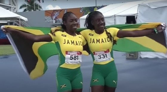 Alexis James (right) and teammate Asharria Ulette celebrate their Jamaica one-two in the girls Under-20 sprint hurdles.