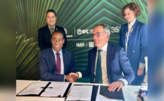 Minister of Finance Dr Nigel Clarke (seated left) seals the deal with an handshake with Alfonso Garcia Mora, IFC’s regional vice-president, Europe, Latin America and the Caribbean, while minister with responsibility for water, environment and climate change Matthew Samuda (standing left) and a member of the IFC team looks on.