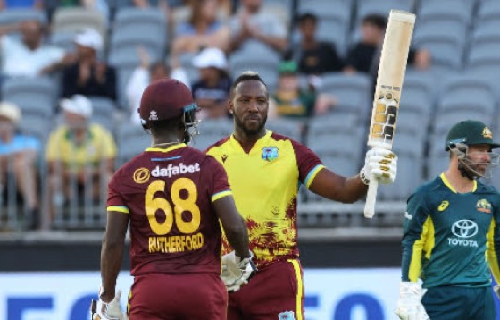 Andre Russell acknowledges his 25-ball fifty against Australia on Tuesday, as he is congratulated by partner Sherfane Rutherford.