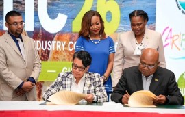 Guyana’s Minister of Tourism, Industry and Commerce Susan Rodrigues, and Jamaica’s Minister of Tourism Edmund Bartlett signing the MOU. (Photo: DPI)