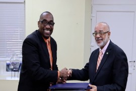 CARILEC executive director, Dr. Cletus Bertin (right) and OECS Director General Dr. Didacus Jules shake hands after signing agreement (OECS Photo)