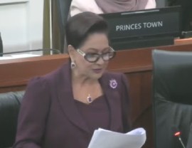 Prime Minister Kamla Persad-Bissessar reading out her statement regarding T7TEC in Parliament on Monday (CCMC Photo)