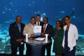 (Right) Industry Investment and Commerce Minister Senator Aubyn Hill receives a copy of the Memorandum of Understanding from CEO of the Georgia Aquarium Dr, Brian Davis. Looking on from left are Dr. Dayne Buddo, Director of Policy at the Georgia Aquarium; Jamaica’s Consul General to Miami, Oliver Mair; President of JAMPRO Mr. Shullette Cox; Jamaica’s honorary consul to Atlanta Dr. Elaine Bryan and the Interim Executive Officer of the Jamaica Special Economic Zone Authority Mrs. Kelli-Dawn Hamilton. (Photo by Derrick Scott)