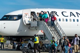 Passengers from Air Canada flight 1066 disembark at Maurice Bishop international airport