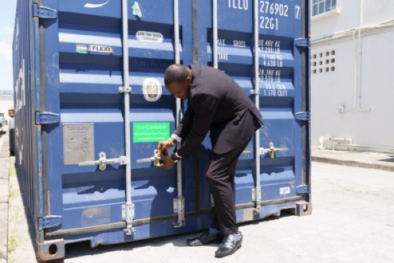 Minister of Industry, Innovation, Science and Technology Davidson Ishmael locks off the container of items produced in Barbados which are being shipped to Ghana.