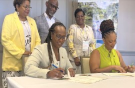 Barbados Tourism Marketing Inc.’s Chief Executive Officer, Andrea Franklin (seated left) and DDA Director, Marva Williams, signing the MOU between Barbados and Dominica while (standing from left to right) BTMI’s COO Cheryl Carter; BTMI’s Director (Caribbean) Graham Clarke; and Marketing Executive at DDA, Lise Cuffy, look on. (BTMI photo)