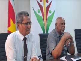 Deputy Minister of the Interior, Maurits Hassankhan, and his director, Nasier Eskak, speaking at a news conference