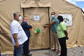 Minister of Health and Wellness, Dr. Christopher Tufton (2nd right) and the Chargé d'Affaires of the U.S. Embassy, John McIntyre (2nd left) cut the ribbon to officially open the 40-bed field hospital at the May Pen Hospital in Clarendon. Sharing in the moment are: Custos of Clarendon, Hon. William Shagoury (left) and Acting CEO of the May Pen Hospital, Eugena Clarke-James.  
