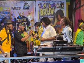 Caption: Gairy Webb (second from left) of The Ramping Shop Family presents a trophy to Whitfield “Witty” Henry, music producer and promoter of the weekly Uptown Mondays dance, at the August 14th edition of Dancehall Thursday in Kingston, Jamaica. Looking on are Papa Michigan (left), Aubrey Douglas and sound system operator Beetle Bailey.