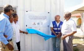 Unveiling the signage on the Solar Energy Community Centre in Galleon Beach. From left, National Fisheries Authority CEO, Dr Gavin Bellamy; Claudene Ebanks, warden, Galleon Fishing Sanctuary; Minister of Agriculture, Fisheries and Mining, Hon. Floyd Green; UNDP Resident Representative Dr Kishan Khoday; Minister of State in the Ministry of Agriculture, Fisheries and Mining, Franklin Witter.