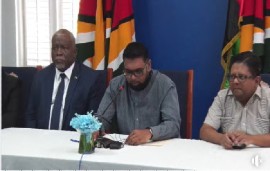 President Dr. Irfaan Ali flanked by Prime Minister Mark Phillips (left) and Finance Minister, Dr. Ashni Singh, at the virtual signing ceremony