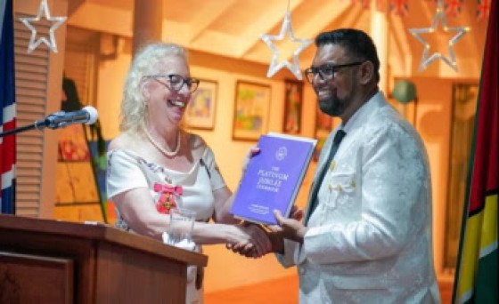 United Kingdom High Commissioner Jane Miller presents a copy of the Golden Jubilee booklet to President Irfaan Ali (DPI Photo)