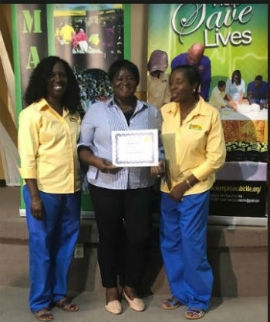 Coach Marlene Hawthorne of St. Jago High receives her certificate from Nurse Delores McGregor (L) & Nurse Sharon Thompson (R)