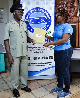 Food For The Poor-Jamaica Director Kivette Silvera gives Superintendent Herbert McFarlane, from St. Catherine Adult Correctional Centre, the funds for the release of three nonviolent offenders from the St. Catherine Adult Correctional Centre. Each newly freed man received food, clothing, personal care items and traveling money.A total of 49 nonviolent offenders were freed from their prisons in Guyana, Haiti and Jamaica for Holy Week (Photo/Food For The Poor)