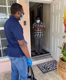 Commissioner Monestime delivers food to a local senior.