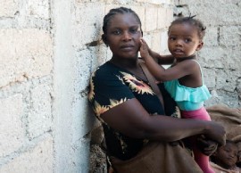 A mother in Léogâne, Haiti, holds her child in a makeshift site for recently displaced people. (UNICEF/Maxime Le Lijour Photo)