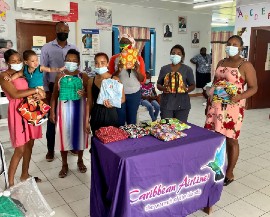 Caribbean Airlines Sales Executive in Guyana Dion Inniss (in back row) was on hand to assist with the distribution  of DFG hygiene kits  to women attending clinic at the Vivienne Health Centre in Linden Guyana on Tuesday April 27, 2021.  DFG’s liaison Allison Grant is also in backrow (third right)