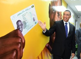 Prime Minister Andrew Holness views the design of the National Identification card which is to be produced under the National Identification System (NIDS). (JIS Photo)