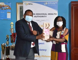 SRHA Regional Director, Michael Bent presents a token of appreciation to SRHA Supervisory Nurse Practitioner & Regional Rheumatic Fever Coordinator, Andrienne Sylvester at the recognition ceremony of nurses and midwives in the SRHA.