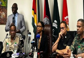 Minister of Home Affairs, Oneidge Walrond (center), during Tuesday night’s media briefing.