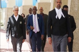 Prime Minister Dr. Keith Rowley (center) flanked by his lawyers and security on his way to the High Court (Photo Trinidad Guardian) Newspaper)