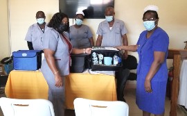 SRHA Acting Regional Mental Health Officer, Karen Elliott (left) presents the restraints to Director of Nursing Services, Maria Stampp for the Black River Hospital (right). Photographed also are (back-left to right)-Psychiatric Nursing Aides- Omar Daley, Denetra Tucker-Steele and Patrick Henry.