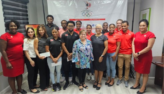 Trinidad and Tobago athletes and representatives share a photo after collecting their monetary rewards for medalling at the Central American and Caribbean (CAC) Games in Santo Domingo