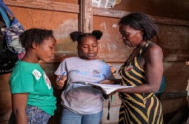 Dieussika shows her family her school work (Photo UNICEF/Herold Joseph)