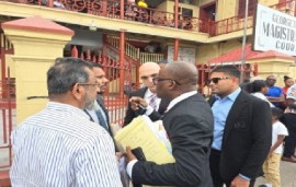 Azruddin Mohamed, wearing shades, listens as the lawyers discuss trheir case after appearing in court on Monday