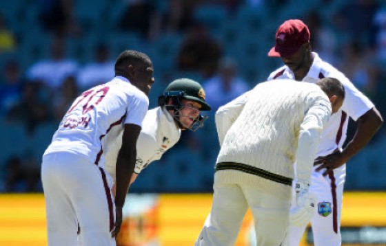 A concerned Shamar Joseph (left) looks on after hitting opener Usman Khawaja (third from left) on Friday’s third day at Adelaide Oval. Kemar Roach (right) and Steve Smith also look on.