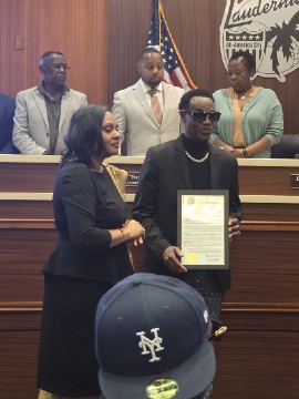 Singer Wayne Wonder shows his Humanitarian Ambassadors Award which was presented to him by Lauderhill Mayor Denise D. Grant (at left) on February 23rd at Lauderhill City Hall. (Contributed photo)