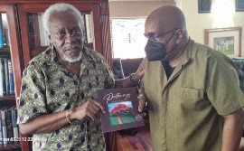 Lennie Little-White (right) presents a copy of his book, Pathways, to former Jamaica prime minister P.J. Patterson at his residence in Kingston, Jamaica