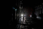 People are seen walking through a darkened street in San Juan. (Ricardo Arduengo / AFP - Getty Images)