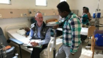 Dr. Paul Farmer (seated) visits the pediatric ward at University Hospital in Mirebalais, Haiti, in December 2016. (Katherine Kralievits / Partners In Health )